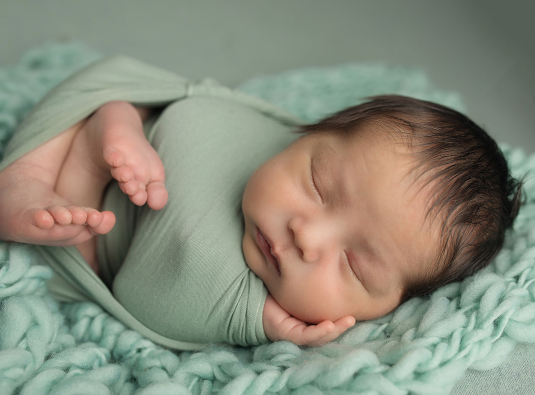Newborn session in windsor ontario with Jillian Wilhelm Photography  in Windsor Ontario on green backdrop with knitted blanket